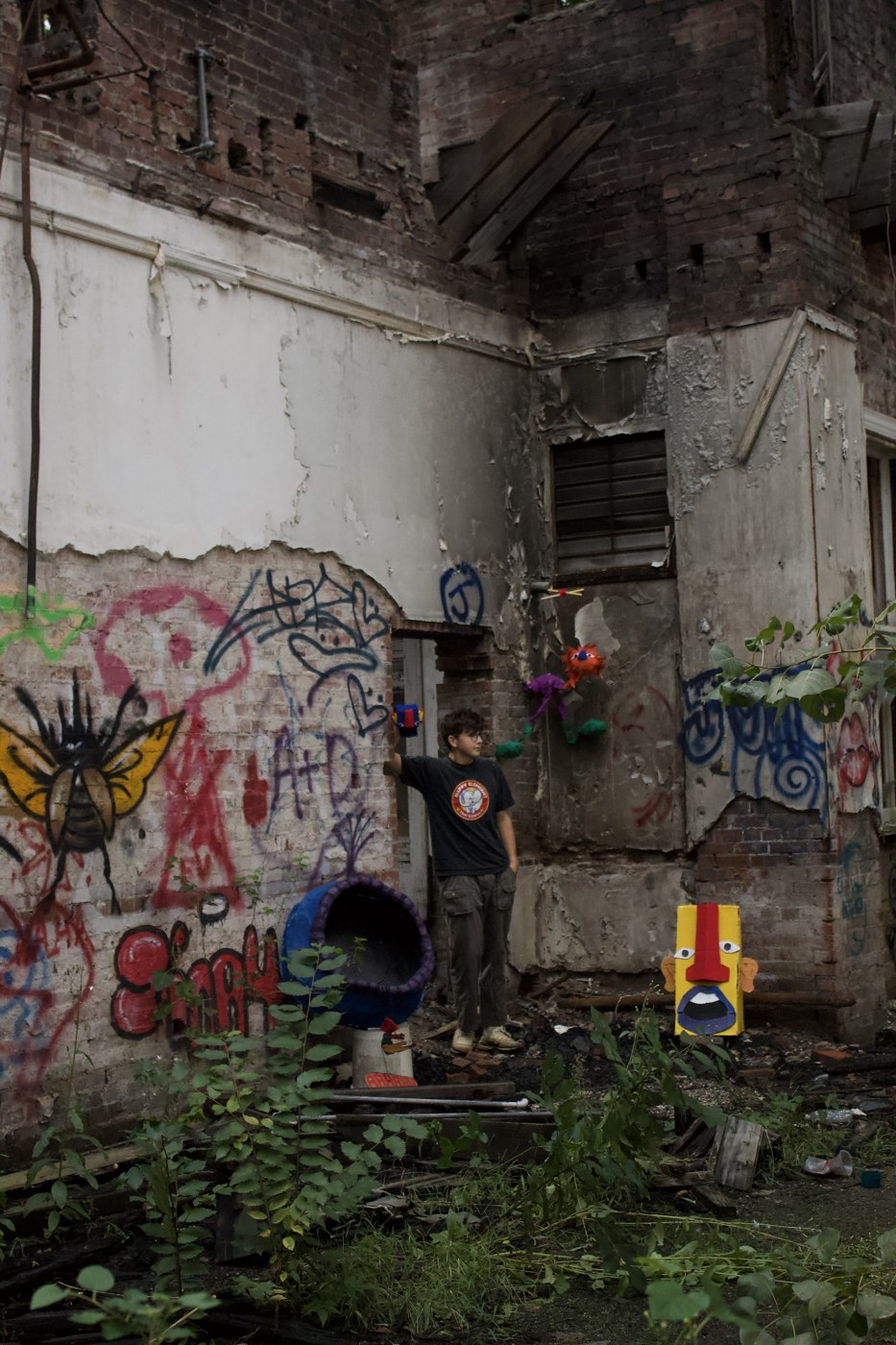 In the Midst of the Broken — figure beside graffiti wall